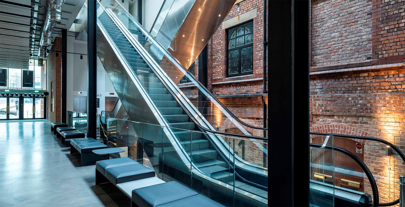 Escalator hall set against the restored Victorian brick facade