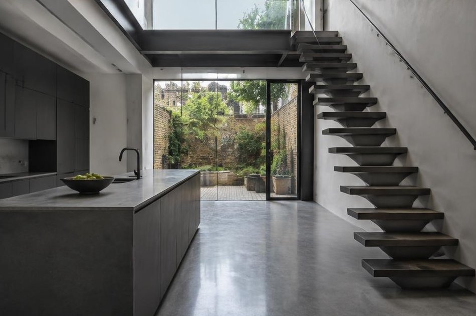 Contemporary kitchen with open stair and garden glazing in Angel