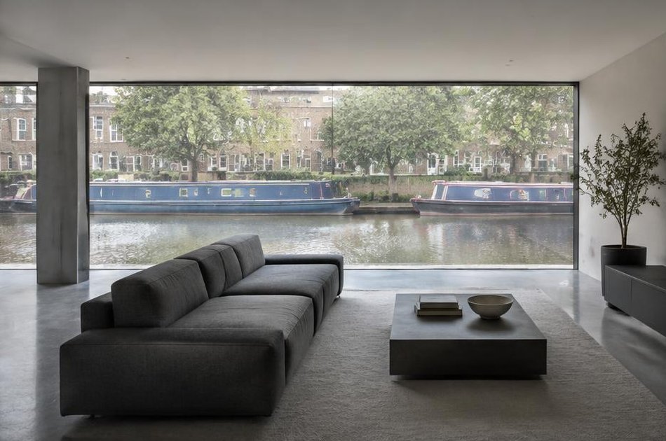 Minimalist living space with broad glazing onto local streets in Angel