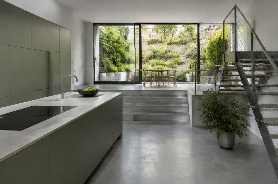 Contemporary kitchen with open stair and garden glazing in Archway