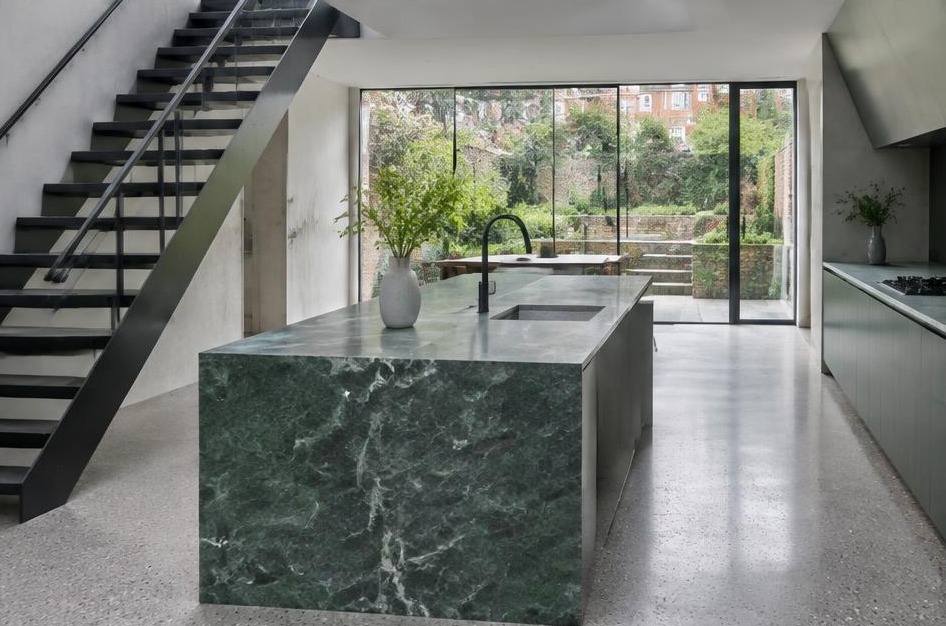 Completed contemporary kitchen with open staircase and garden glazing in Barnes
