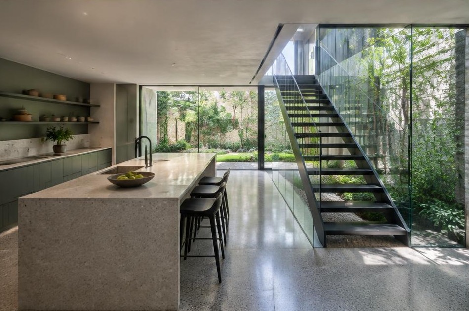 Completed contemporary kitchen and open staircase with garden glazing in Belsize Park