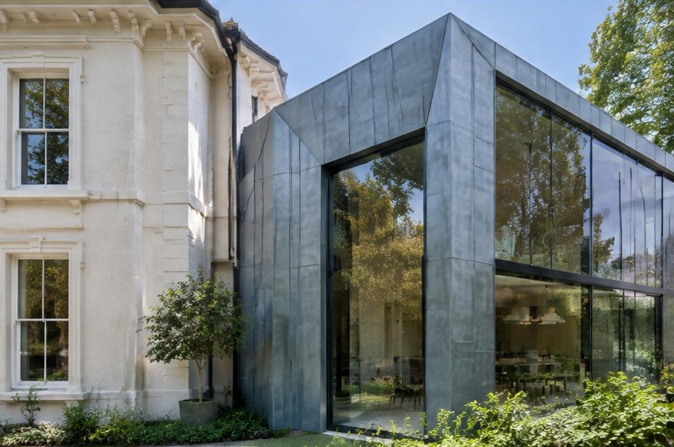 Retained historic facade beside a dominant contemporary glazed addition in Belsize Park