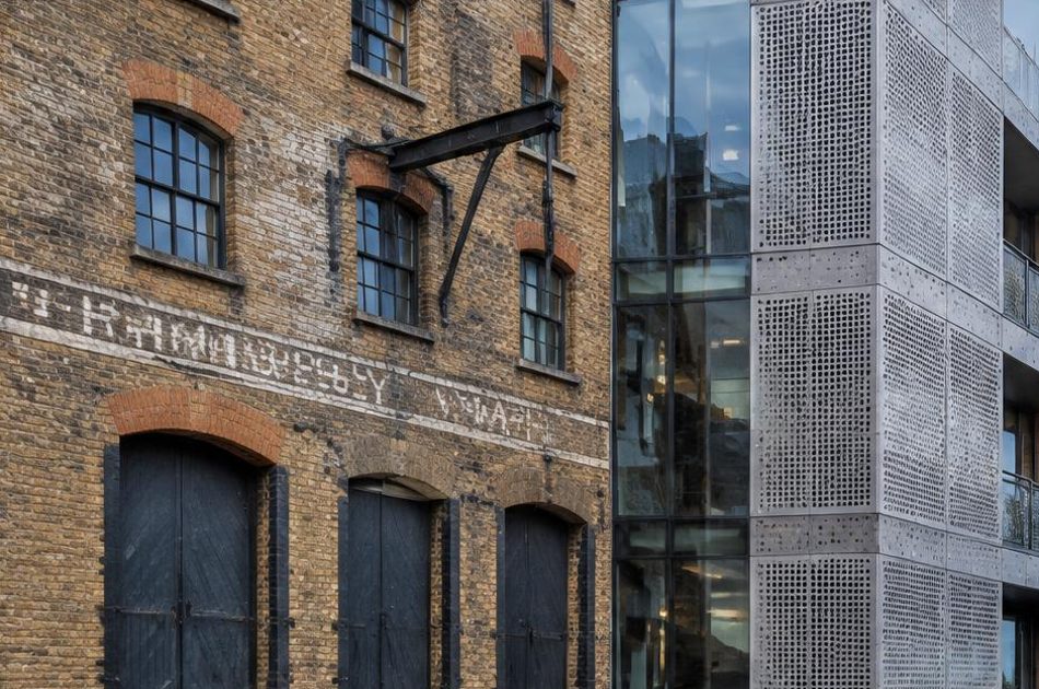 Retained historic facade directly beside a contemporary glazed residential addition in Bermondsey