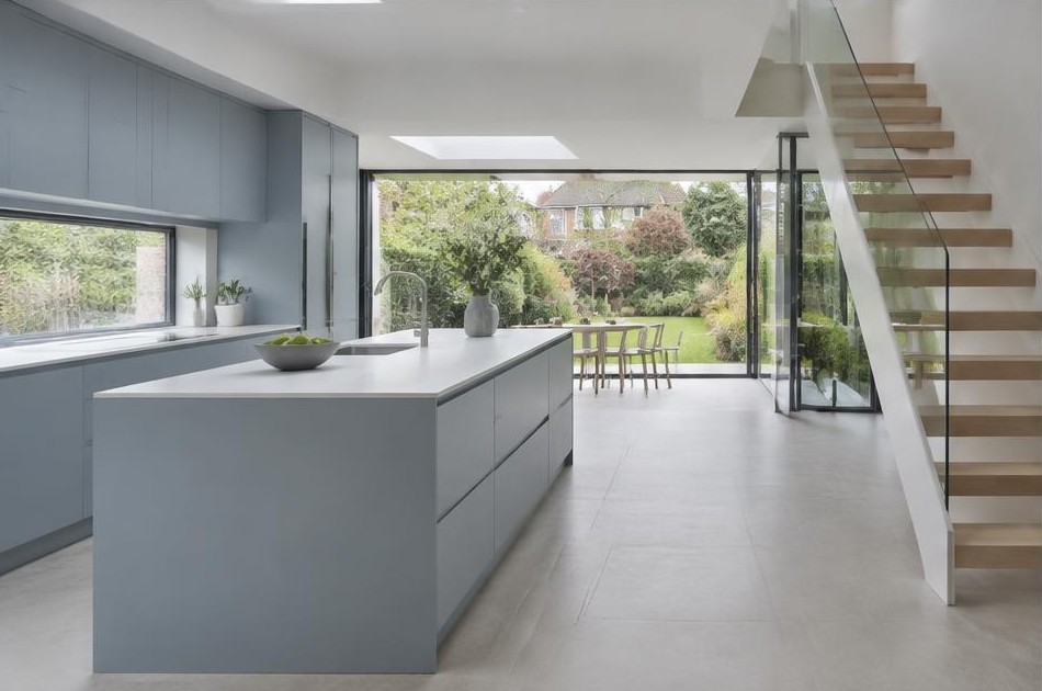 Completed contemporary kitchen with open staircase and garden glazing in Berrylands