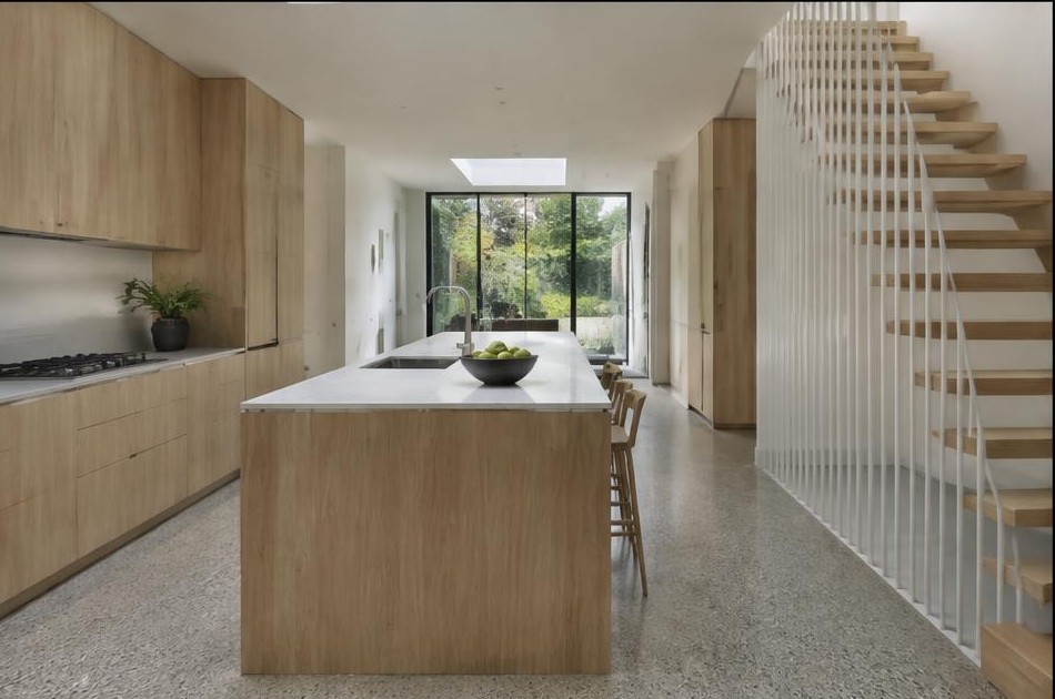 Completed contemporary kitchen with open staircase and garden glazing in Bethnal Green