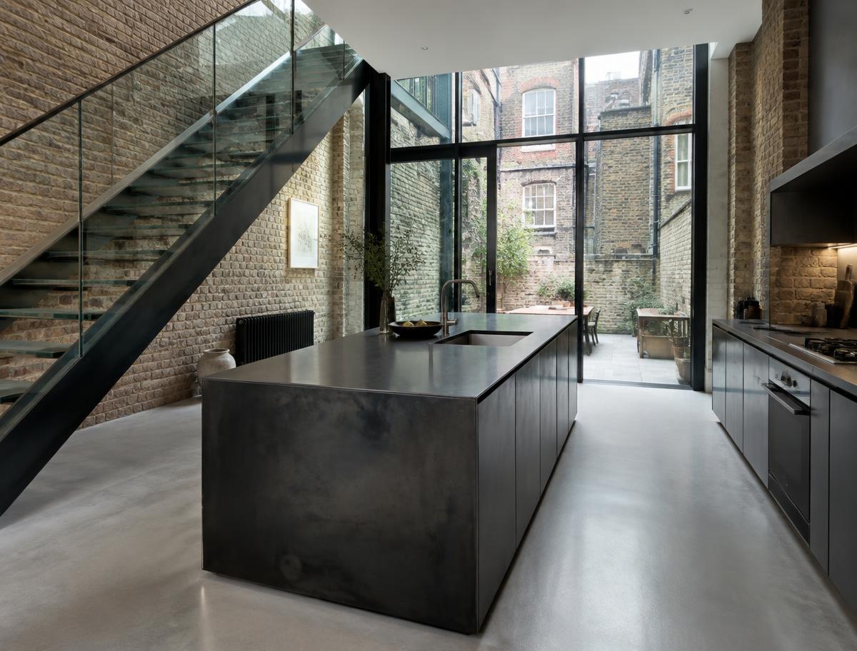 Contemporary kitchen with an open staircase and glazing onto a residential garden in Borough