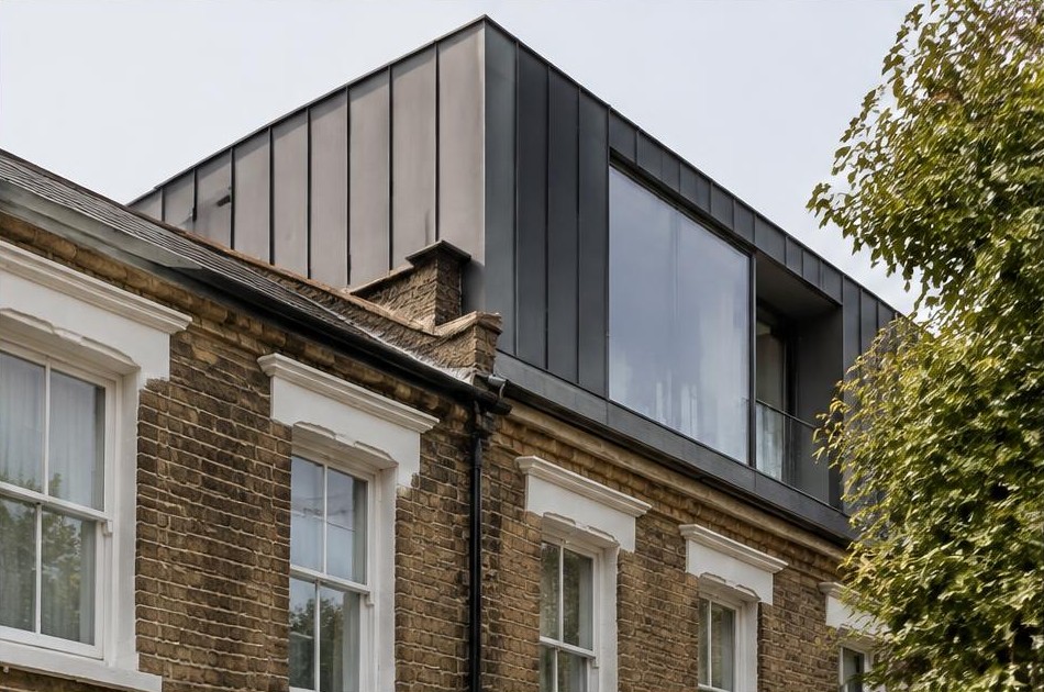 Retained original facade beside a dominant contemporary glazed addition in Bow