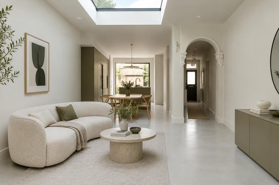 Refurbished interior with a curved sofa and retained hallway arch in Bowes Park