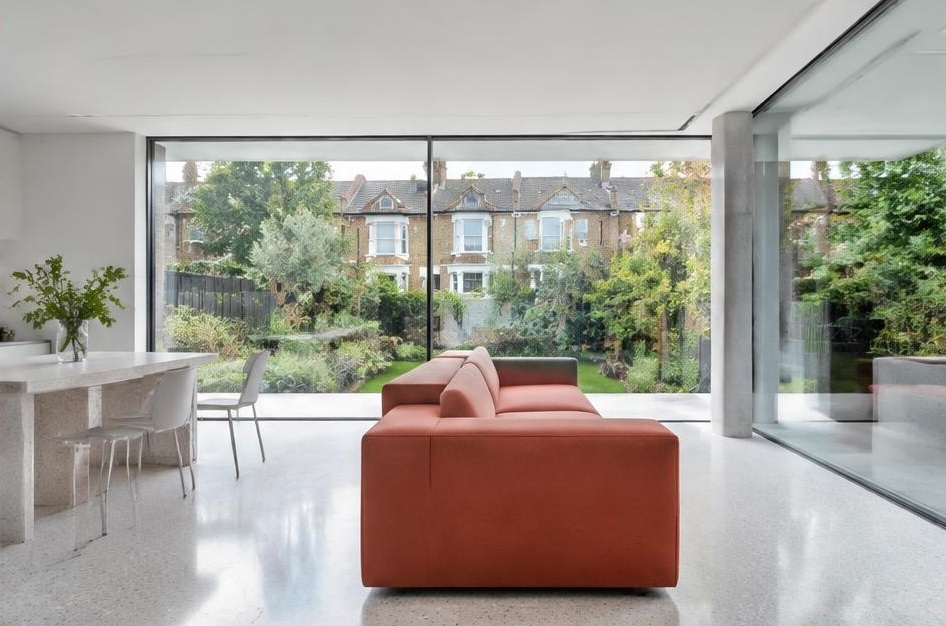 Minimalist living room with a structured fabric sofa and views of Brackenbury Village homes and gardens