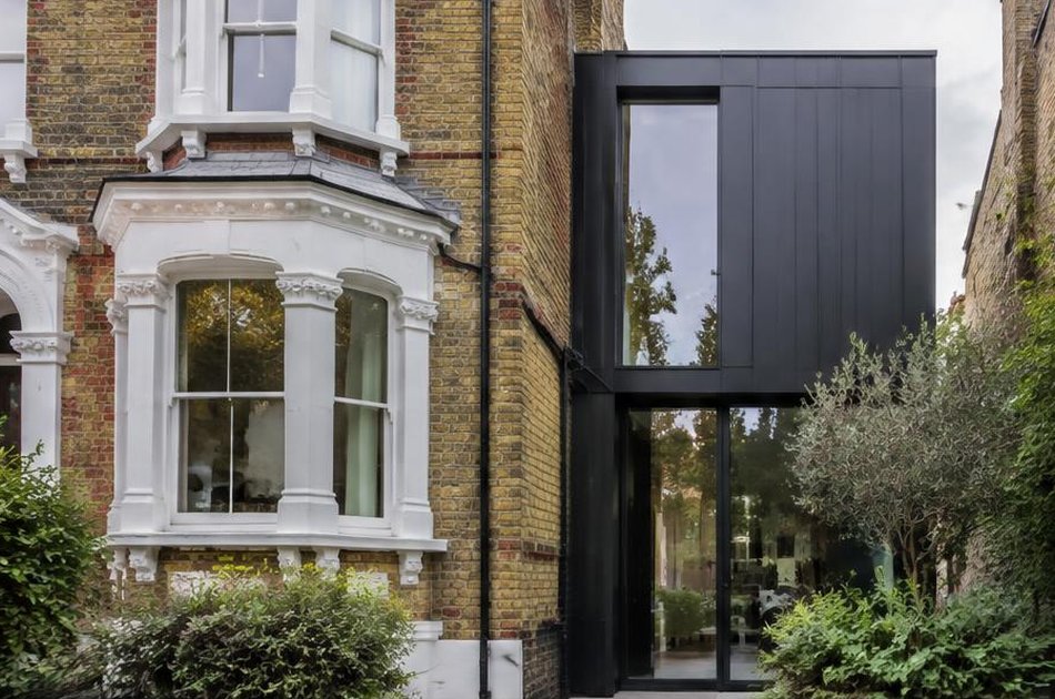 Victorian villa beside a dark metal and glass side extension in Brockley