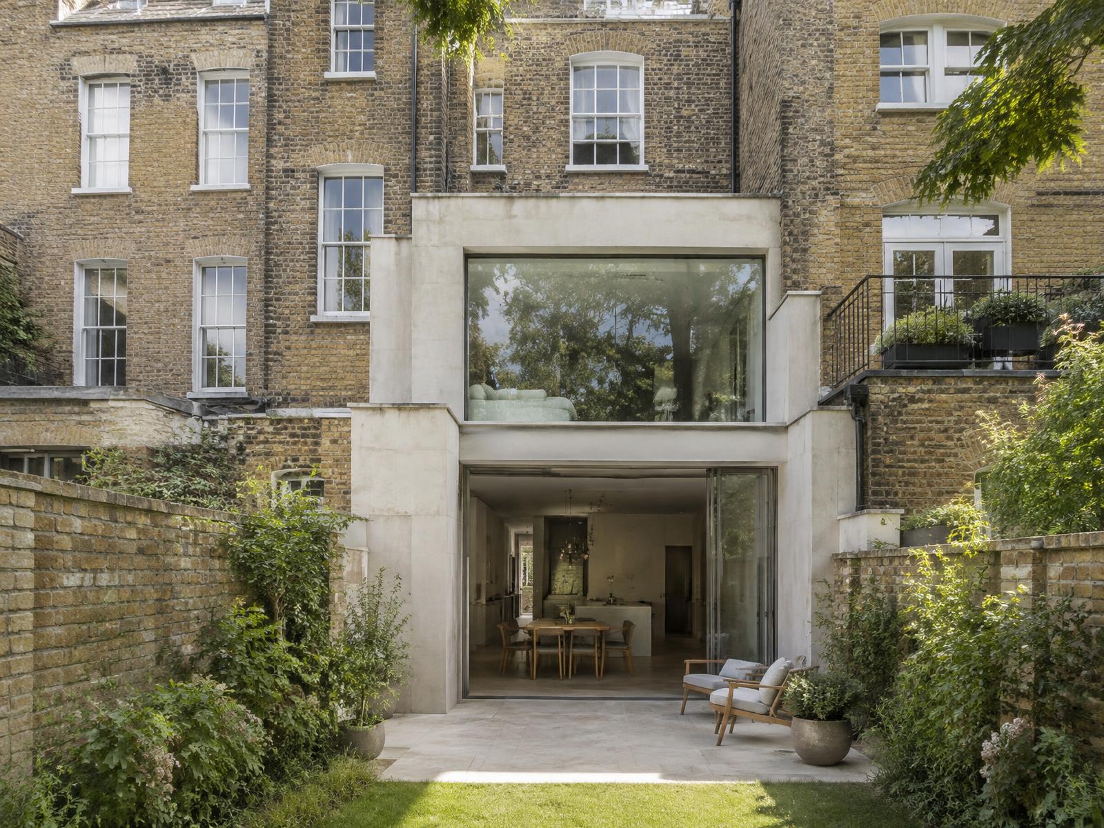 Regency brick terrace house with a pale stone and glass two-storey rear extension