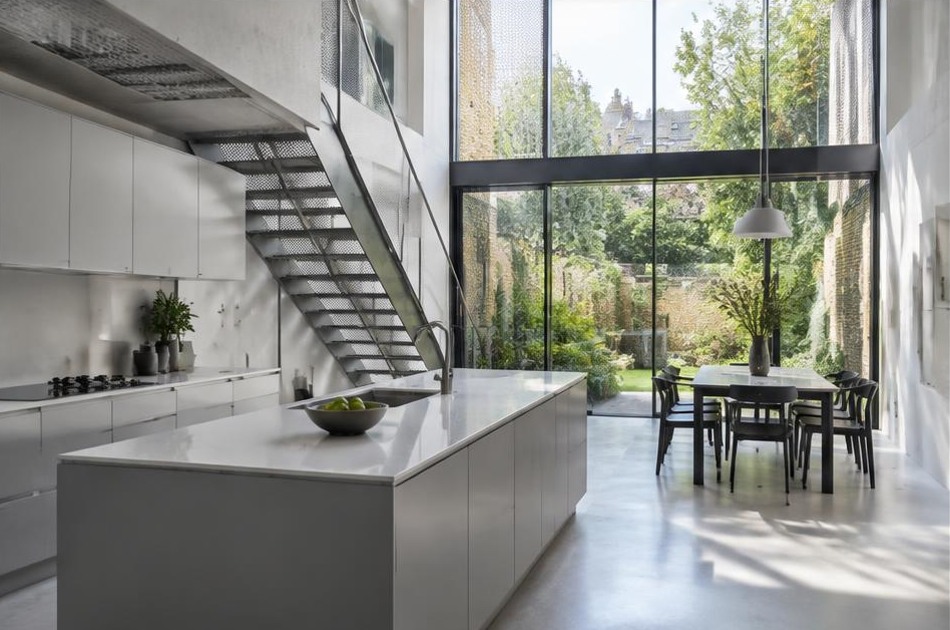 Completed contemporary kitchen and open staircase with garden glazing in Camden