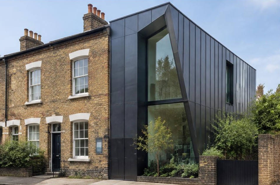 Retained historic facade beside a dominant contemporary glazed addition in Camden Town
