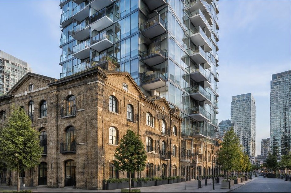 Retained original facade beside a dominant contemporary glazed addition in Canary Wharf