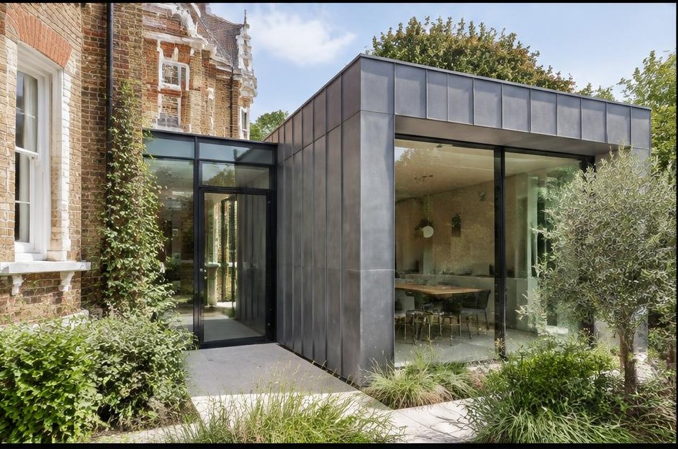 Retained original facade beside a dominant contemporary glazed addition in Canbury
