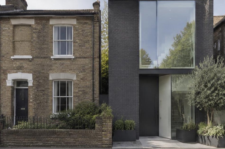 Victorian cottage beside a contemporary dark brick and glass house in Charlton