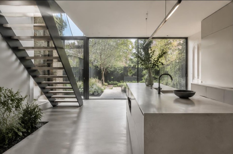 Completed contemporary kitchen with open staircase and garden glazing in Clapton