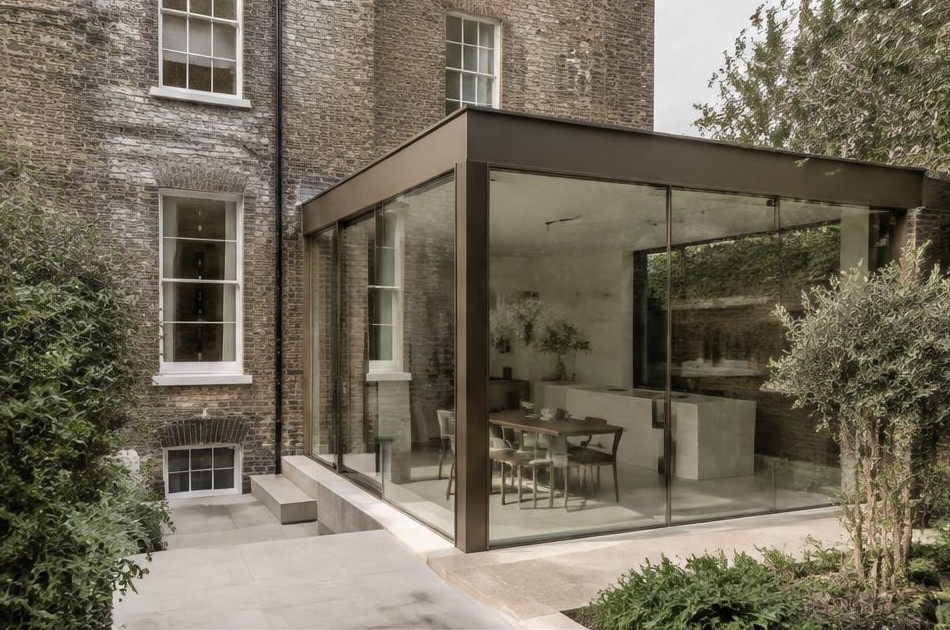 Retained original facade beside a dominant contemporary glazed addition in Clapton