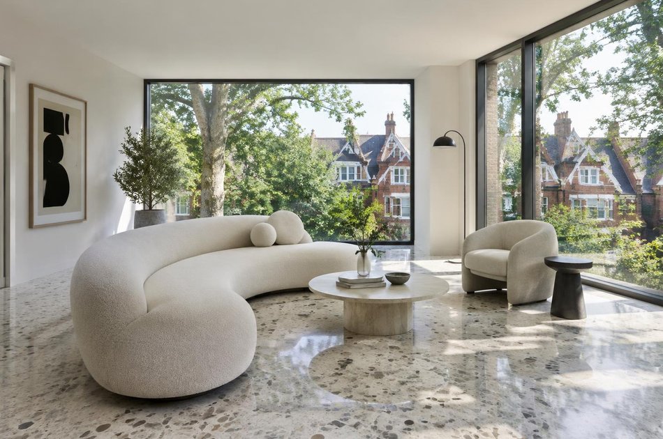 Living room with a curved sofa overlooking gabled villas in Crouch End