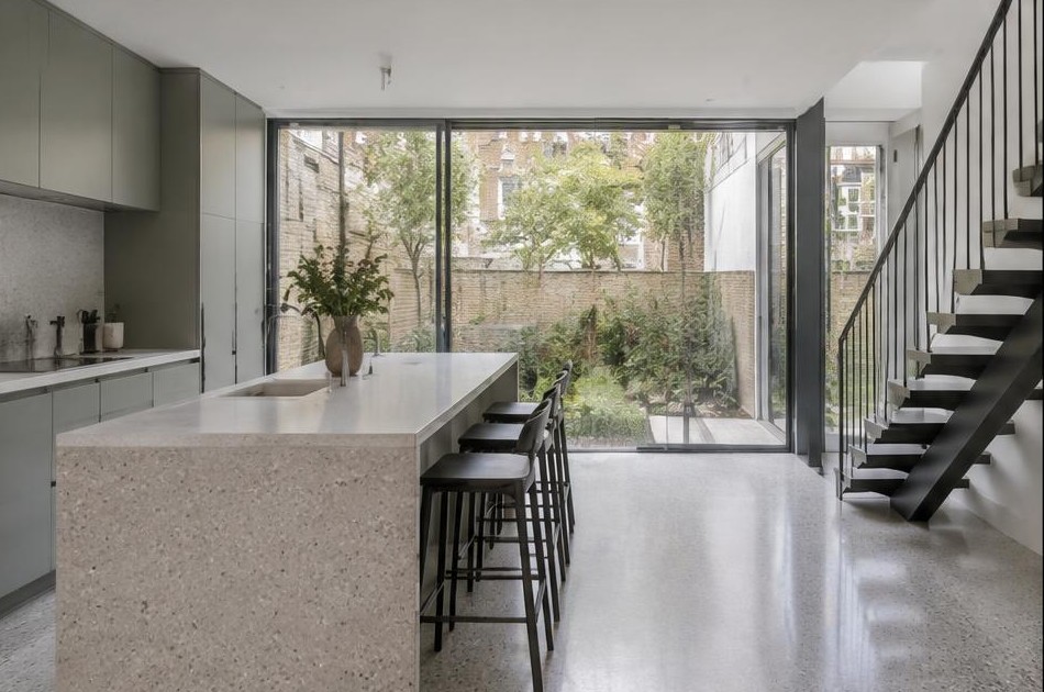 Completed contemporary kitchen with open staircase and garden glazing in Dalston