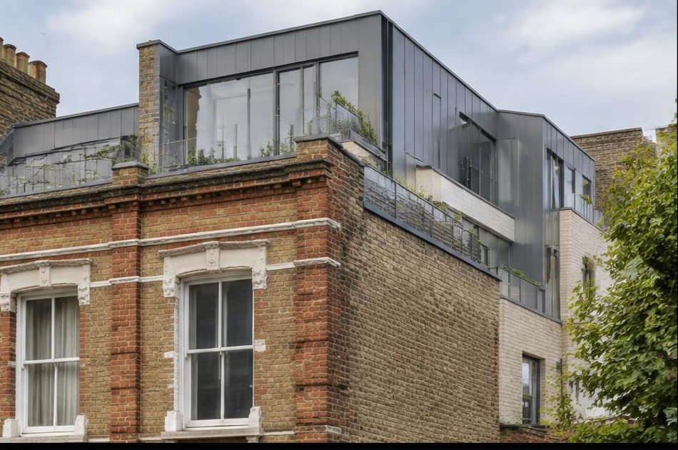 Retained original facade beside a dominant contemporary glazed addition in Dalston