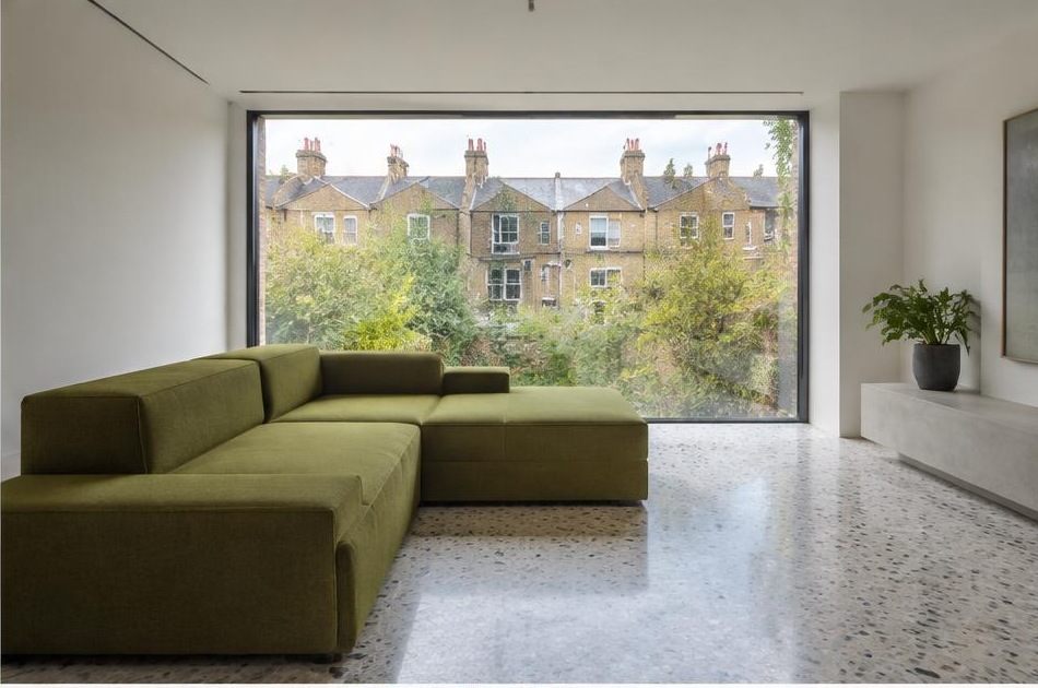 Minimalist contemporary room with straight fabric seating and views onto Earlsfield residential homes and gardens