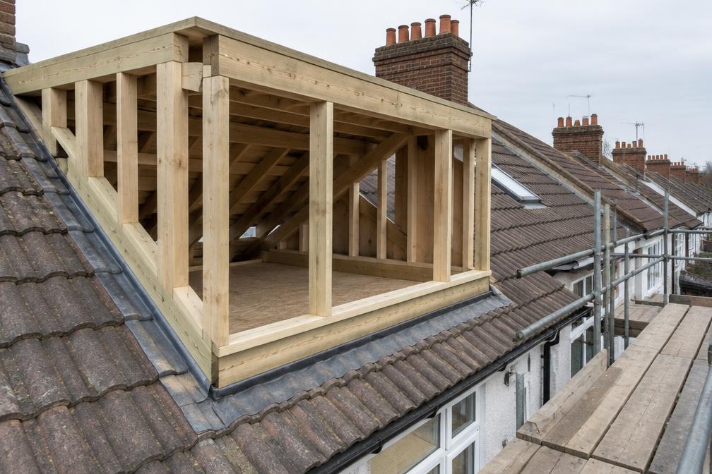 Carpenters framing a loft dormer on a terraced roof