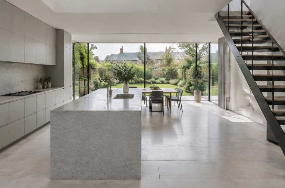 Completed contemporary kitchen with open staircase and garden glazing in East Sheen