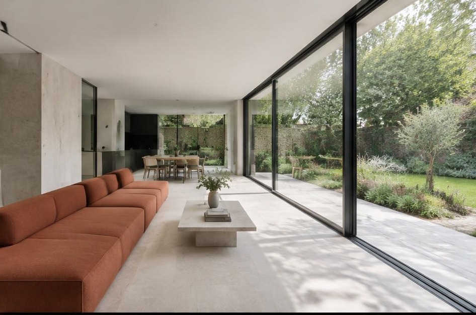 Minimalist garden living space with broad glazing in East Sheen