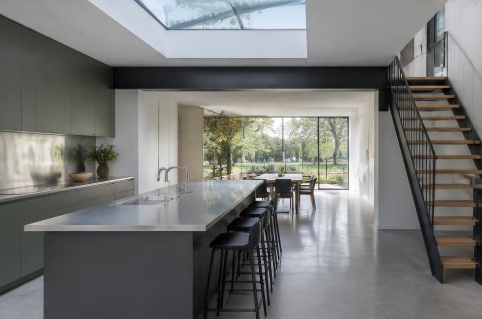 Contemporary kitchen with open stair and garden glazing in Finsbury Park