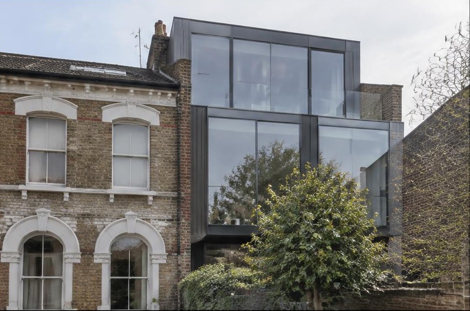 Retained original facade beside a dominant contemporary glazed addition in Hackney Central