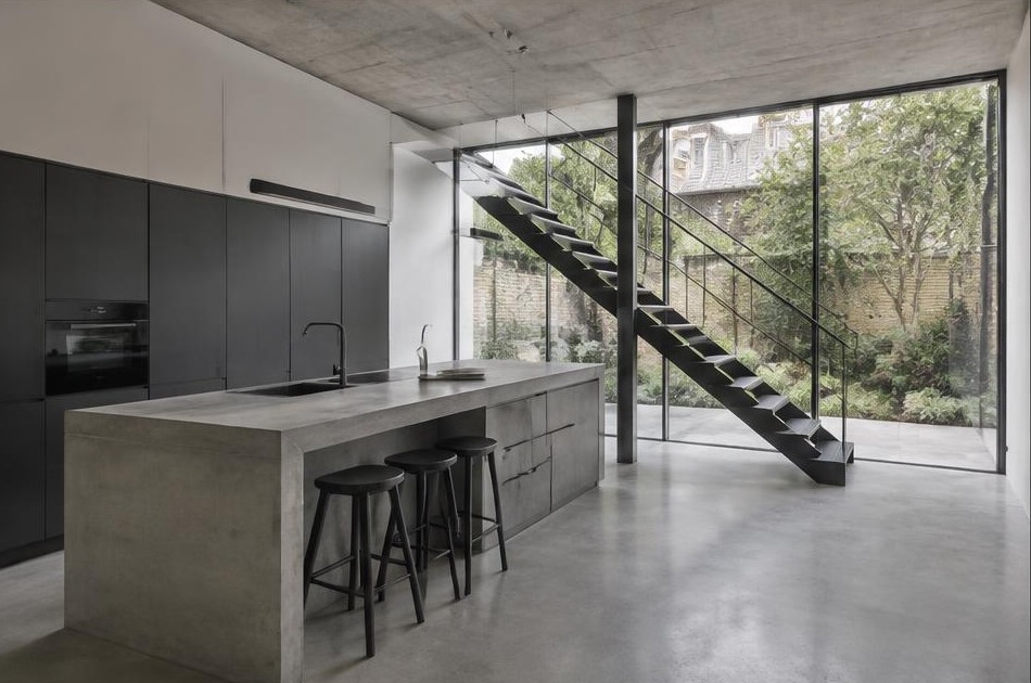 Completed contemporary kitchen with open staircase and garden glazing in Hackney
