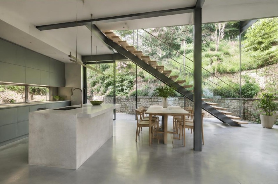 Completed contemporary kitchen and open staircase with garden glazing in Hampstead