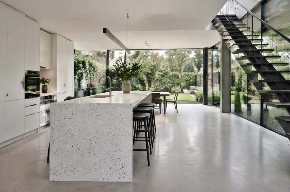 Completed contemporary kitchen with open staircase and garden glazing in Hampton
