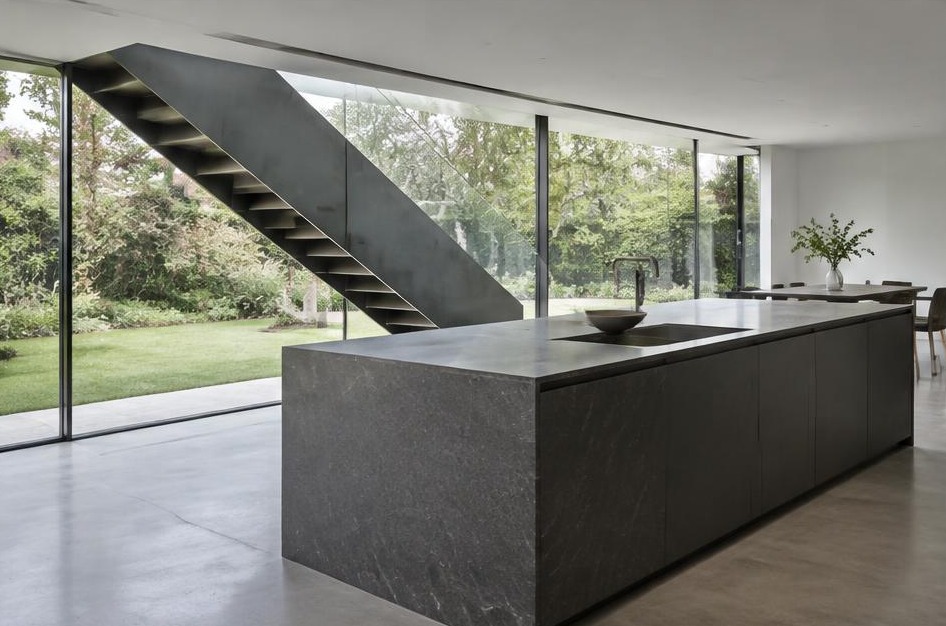 Completed contemporary kitchen with open staircase and garden glazing in Hampton Wick