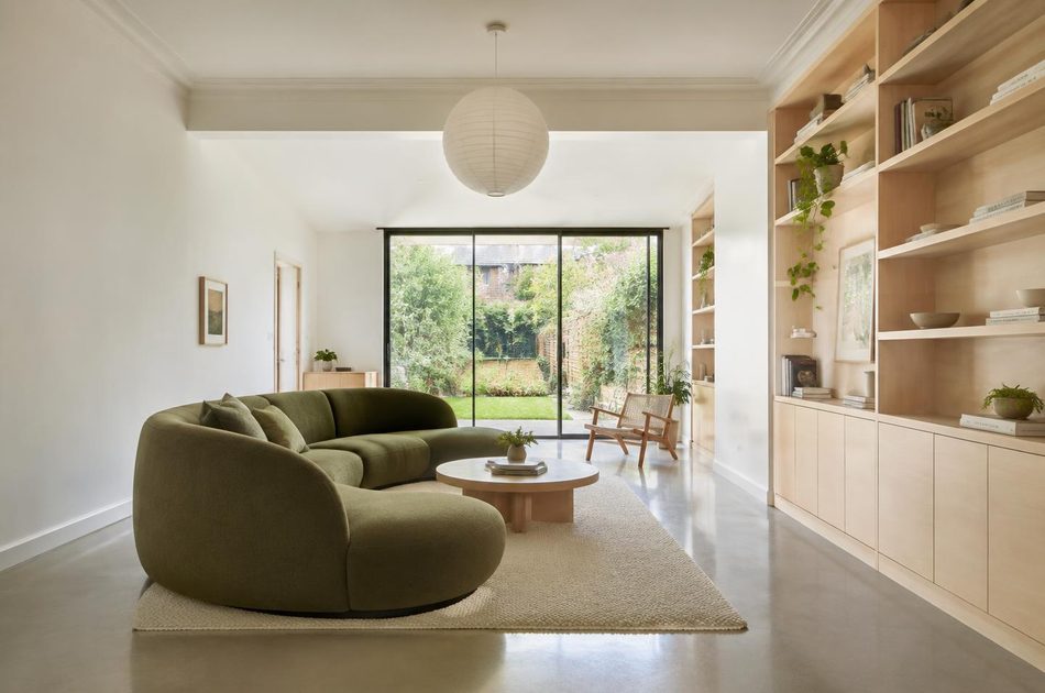 Refurbished Victorian through-lounge with a curved green sofa in Hanwell