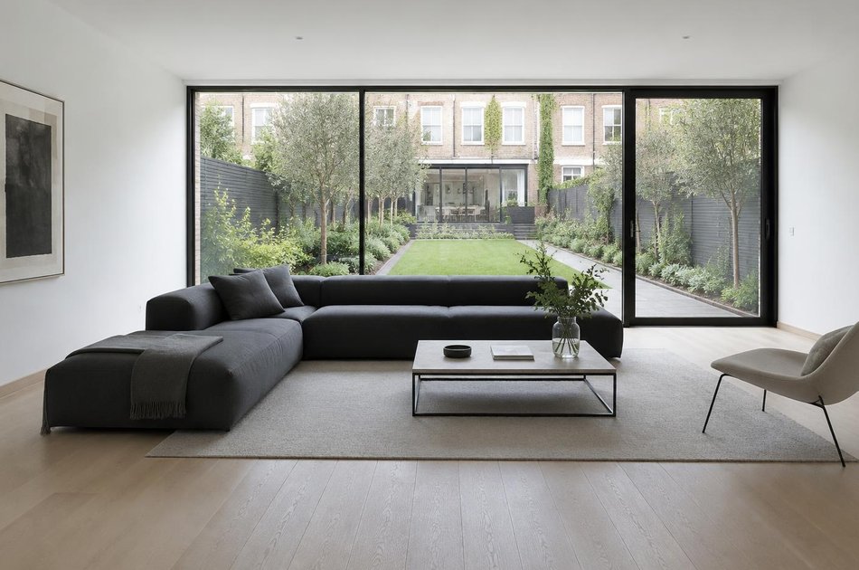 Living room with a linear sofa overlooking a long garden in Harringay