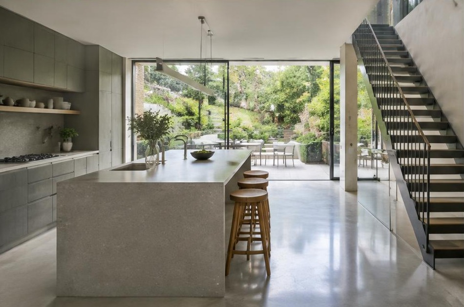 Completed contemporary kitchen and open staircase with garden glazing in Highgate