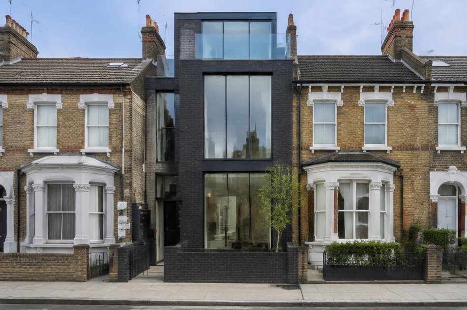 Contemporary dark brick residence beside period buildings in Holloway