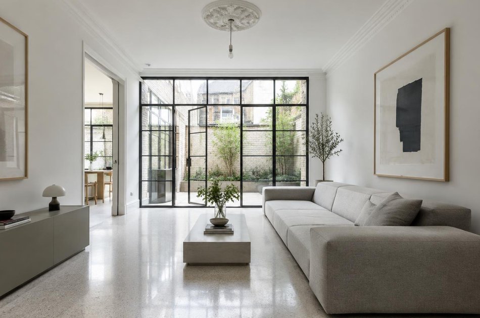 Refurbished interior with a linear sofa and retained ceiling rose in Hornsey