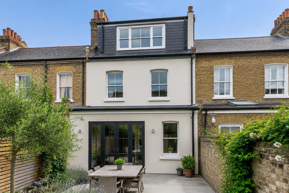 Victorian terrace with a rear dormer in pale render in Ilford