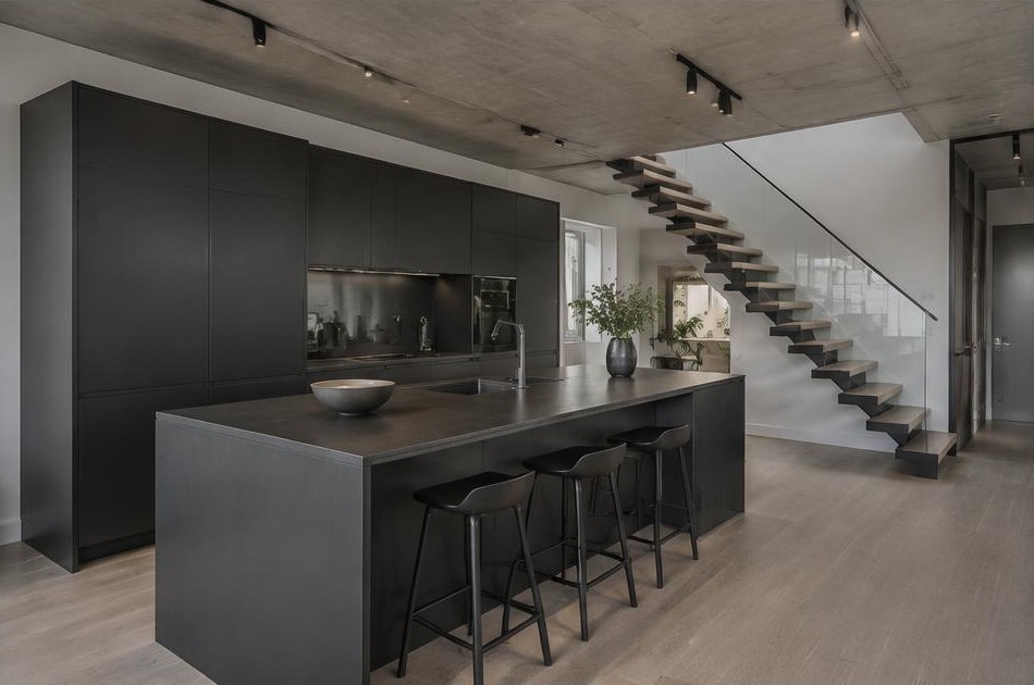 Completed contemporary kitchen with open staircase and garden glazing on the Isle of Dogs