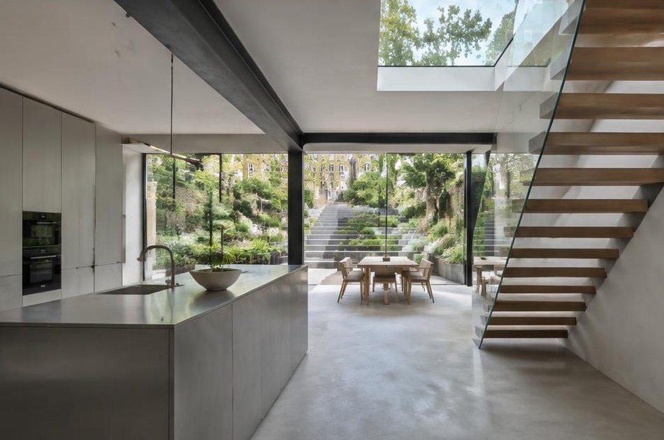 Contemporary kitchen with open stair and garden glazing in Islington