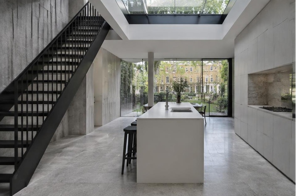 Contemporary kitchen with an open staircase and glazing onto a residential garden in Kennington