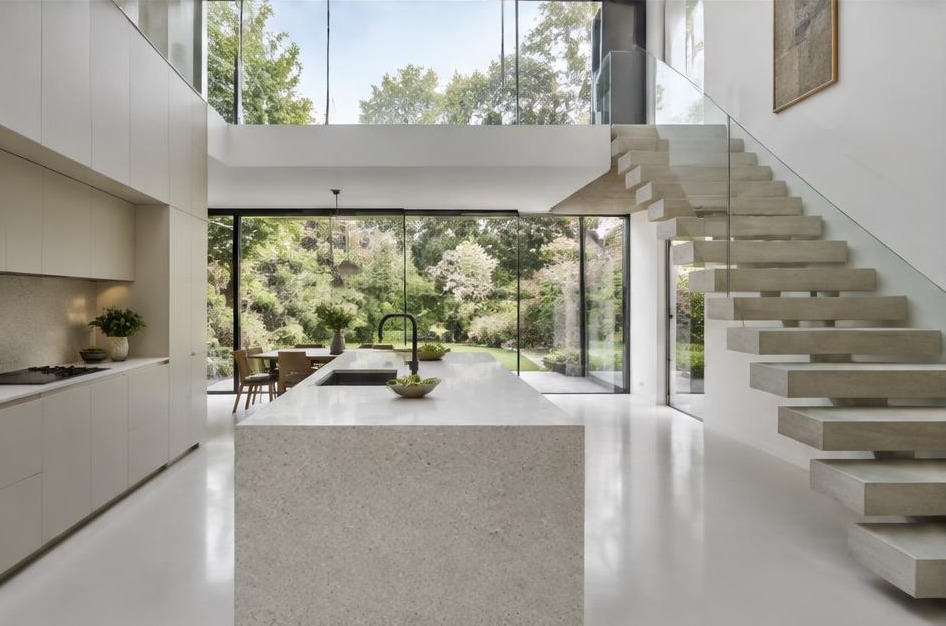 Completed contemporary kitchen with open staircase and garden glazing in Kew