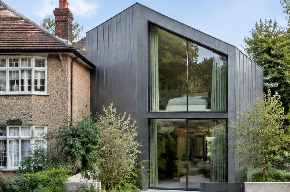 Retained historic facade beside a dominant contemporary glazed addition in Kingston Vale