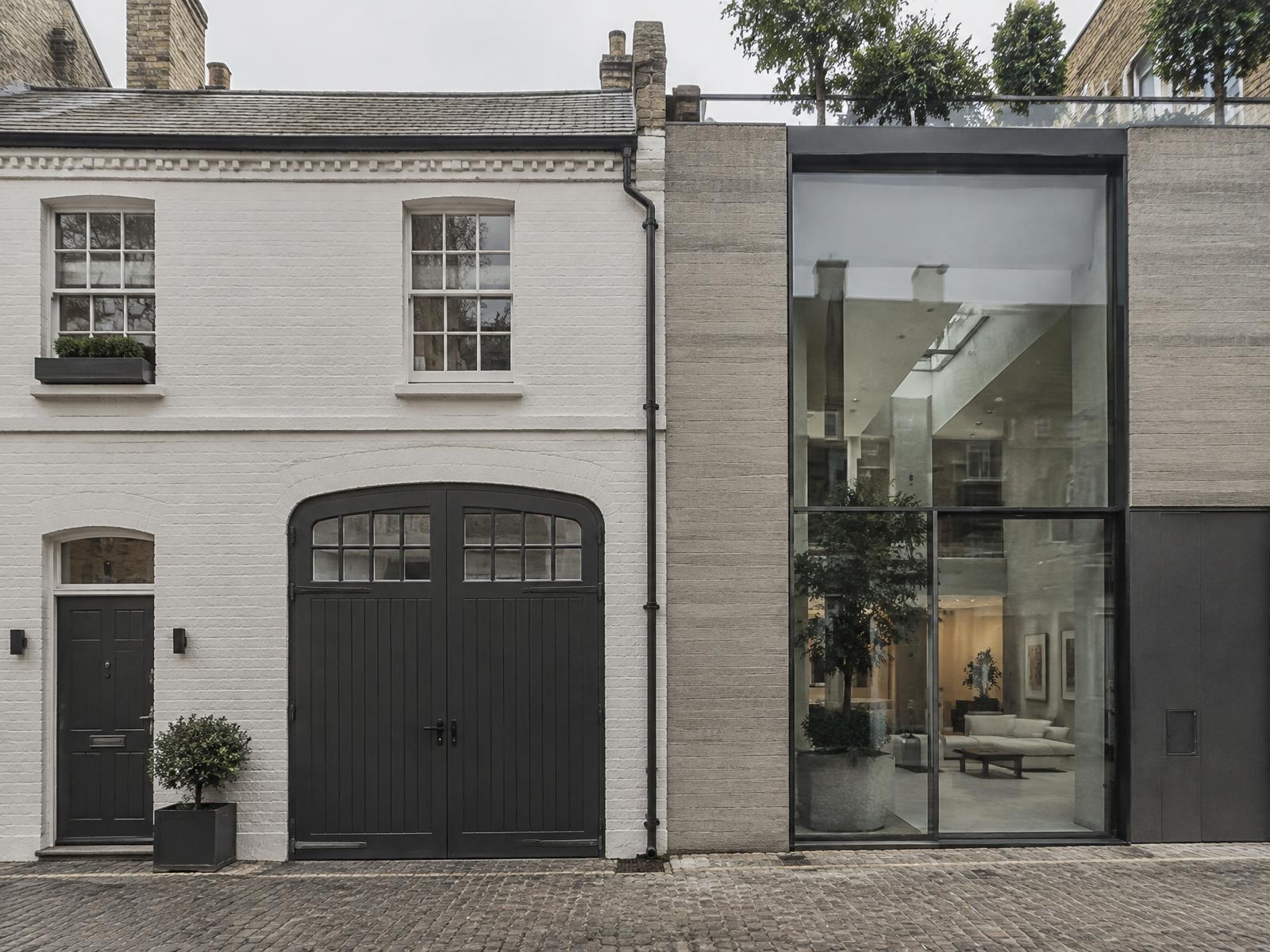 Painted-brick Victorian mews house beside a contemporary board-marked concrete mews house with full-height glazing