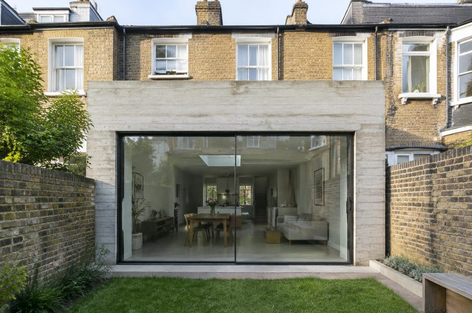 Board-marked concrete rear extension behind Victorian terraces in Ladywell