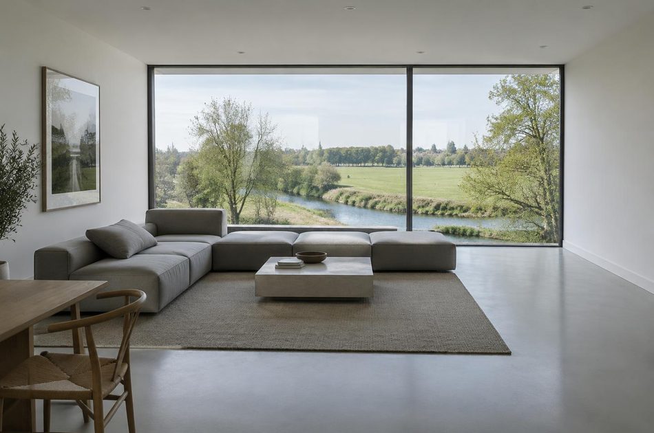 Living room with full-height glazing onto riverside parkland in Ladywell